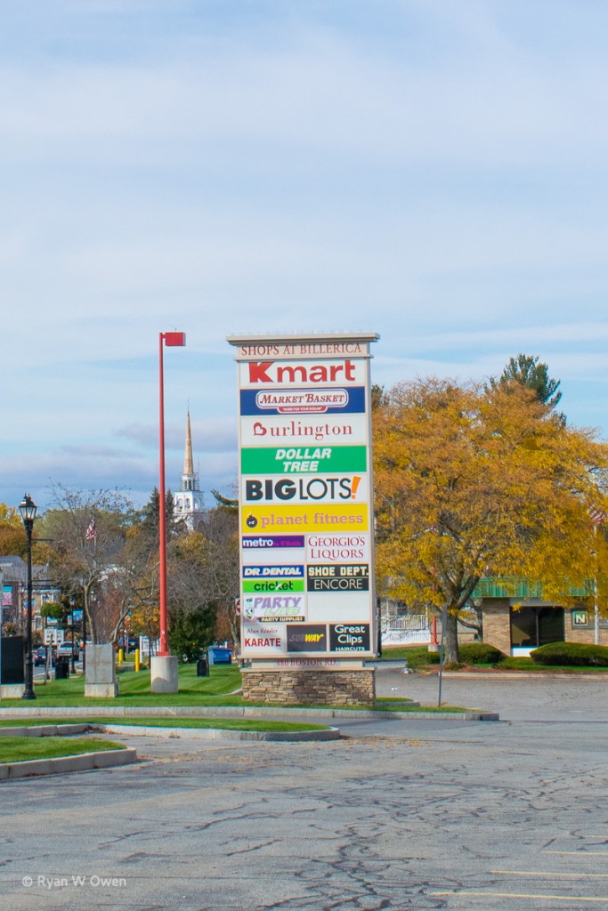 The stores at the Billerica mall as of October 2020 with the spire of the First Parish Church in the background. (Photo by Author) 